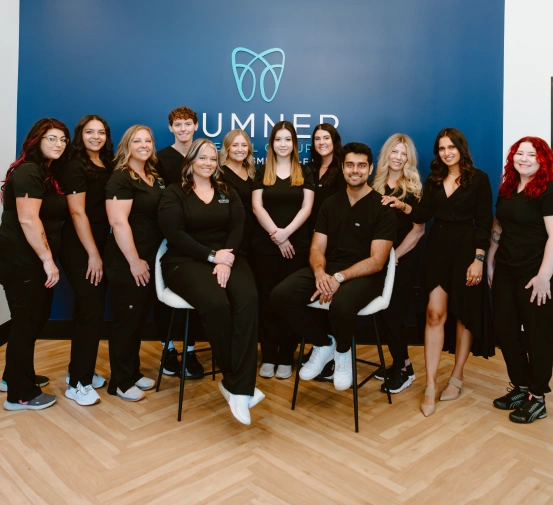 Team of dentists and staff at Sumner Dental Group standing together inside the Gallatin dental office.