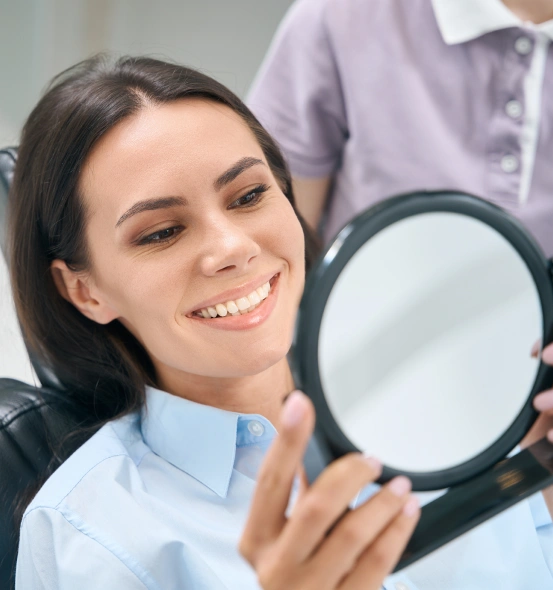 Patient smiling during a routine dental cleaning and oral examination.