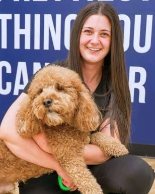 Kelsey, Registered Dental Assistant holding the Sumner Dental Group office dog.