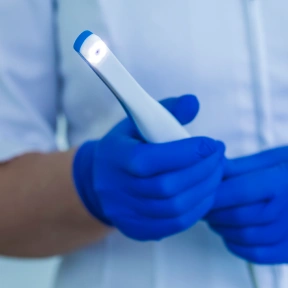 Intraoral camera used during a dental exam to capture detailed images inside the mouth.